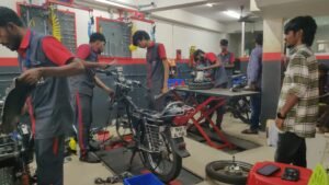 Students repairing motorcycles on workshop lifts